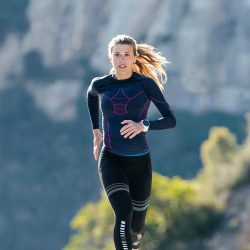 Shot of sporty young woman running on mountain road in beautiful nature.
